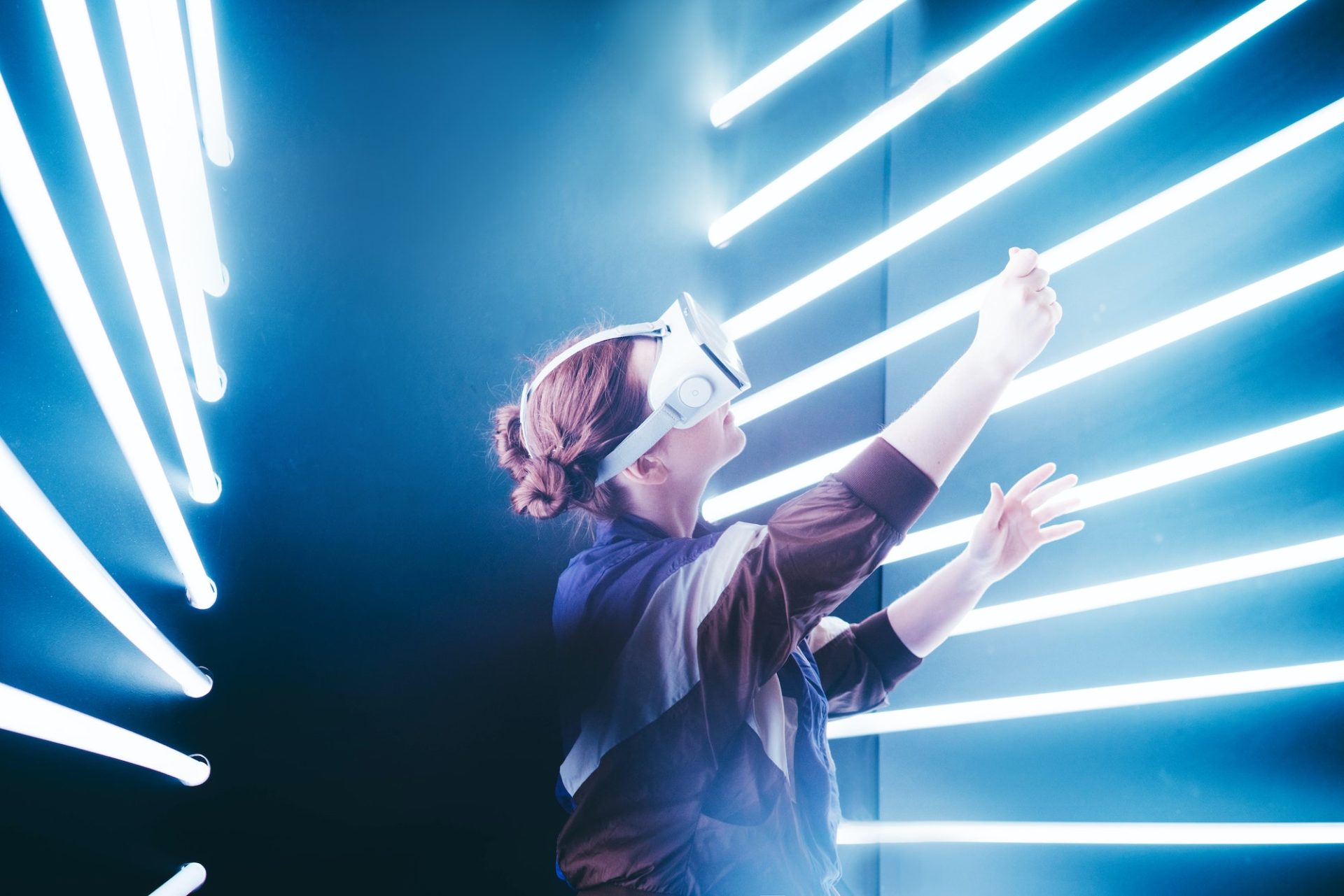 Girl using VR goggles in colorful neon lights